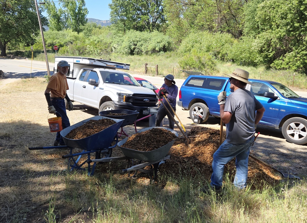 John, Dave and Jim loading wheelbarrows with mulch